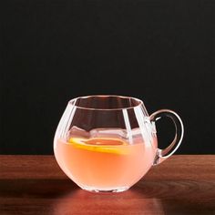 a pitcher filled with liquid sitting on top of a wooden table