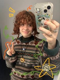 a woman holding up her cell phone in front of her face and making the peace sign