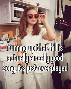 a girl in white pants and sunglasses standing next to a refrigerator with the caption running up that hill is actually a really good song, it's just overplayed