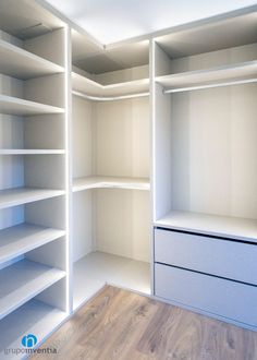 an empty walk in closet with white shelving