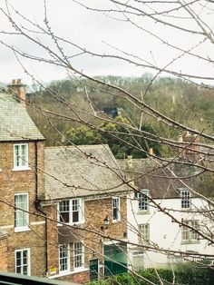 an old brick building sitting next to a lush green hillside