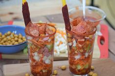 two glasses filled with food sitting on top of a table