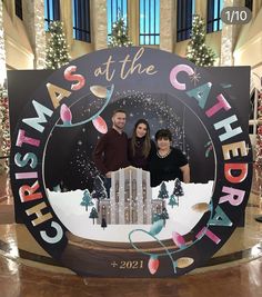 two people standing in front of a sign that says christmas at the city center with lights on