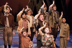 a group of people standing on top of a stage with their hands in the air