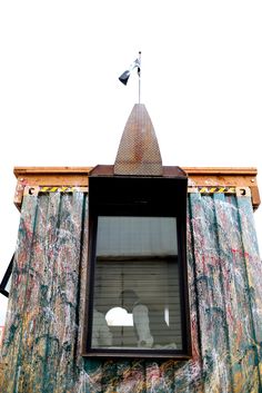 a building with graffiti on the side and a flag sticking out of it's window