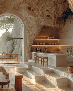 the interior of a cave house with stone walls and steps leading up to an outdoor kitchen