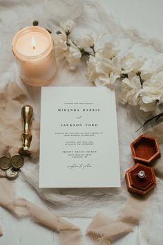 an elegant wedding suite is laid out on a bed with white flowers and gold accents