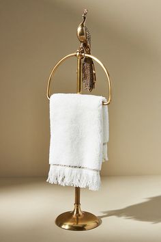 a white towel hanging on a gold stand