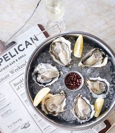 oysters on the half shell with lemon wedges and garnish in a pan