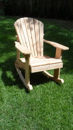 a wooden chair sitting on top of a lush green field