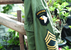 an army green jacket with patches on the chest and eagle patching down the back