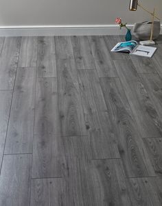 a grey wood floor in a room with white walls and gray tile on the floor