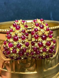 An impressive pair of earrings done in deep 18K yellow gold and set with 3.81cttw in fancy vivid yellow diamonds ranging Si2-I2 clarity as well as 11.12cttw in bright red cabochon rubies (all weights are stamped and exact) . A beautiful pair of earrings that look like no other. They have posts with oversized pushbacks. Dimensions/Weight: Earrings 1.25" by .80" and weigh 27.2g. Condition: All stones are secure and in perfectly wearable condition. E-AHHJ Luxury Yellow Multi-stone Jewelry, Luxury Ruby Earrings For Evening, Exquisite Multi-stone Yellow Gold Earrings, Exquisite Yellow Gold Multi-stone Earrings, Yellow Multi-stone Fine Jewelry, Gold Multi-stone Diamond Earrings, Gold Diamond Multi-stone Earrings, Yellow Gold Multi-stone Jewelry For Evening, Exquisite Yellow Gold Clip-on Earrings