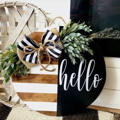 a black and white sign that says hello with a bow on it next to a basket