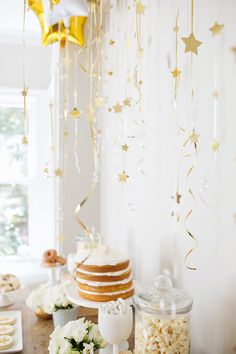 a table topped with lots of food and confetti on top of cake plates