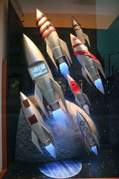 a display case with several model rockets in it