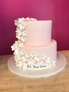 a pink and white cake with flowers on it