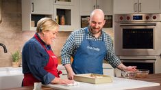 a man and woman in the kitchen preparing food