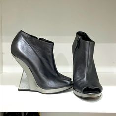 Metallic Gray Salvatore Ferragamo Open Toe Booties With A Pvc Heel Luxury Closed Toe Boots For Spring, Formal Open Toe Leather Boots, Luxury Open Toe Leather Boots, Luxury Leather Open Toe Boots, Designer Spring Boots With Leather Sole, Designer Boots With Contrasting Heel Counter, Designer Round Toe Leather Heels, Designer Closed Toe Boots With Leather Lining, Designer Ankle-high Leather Heels