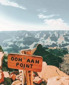 a wooden sign sitting on the side of a mountain