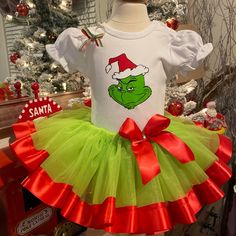 the grin face is wearing a santa hat and green tutu skirt