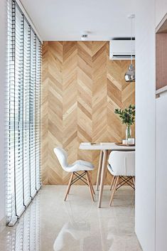 two chairs and a table in a room with wood paneling on the wall behind them