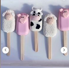 four pops with farm animals on them and one is pink, the other is white