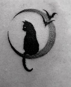 a black cat sitting on top of a crescent with the moon in it's center