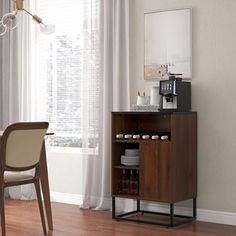 a dining room table with chairs and a small cabinet in front of the window next to it