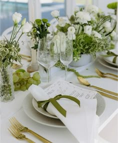 the table is set with wine glasses, plates and napkins for dinner guests to enjoy