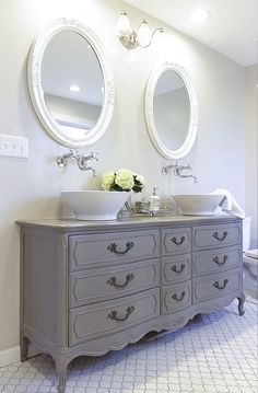 a bathroom with two sinks and mirrors on the wall