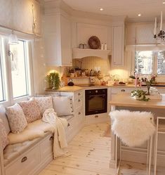 a kitchen filled with white furniture and lots of counter space next to a stove top oven