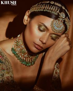 a woman in a gold and green outfit with her hands on her head, posing for the camera