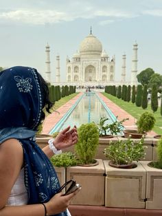 a woman in a headscarf looking at the taj - ihane