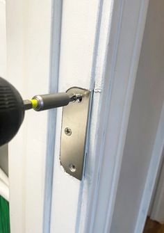 a close up of a door handle with a screwdriver on it