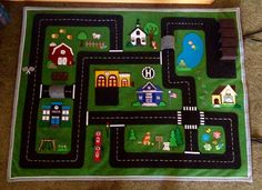 a child's play mat with cars and houses on it