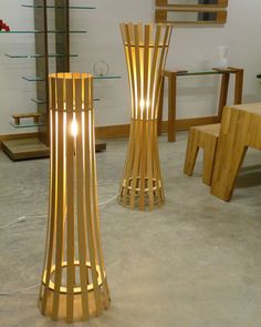 two tall wooden lamps sitting next to each other on top of a carpeted floor