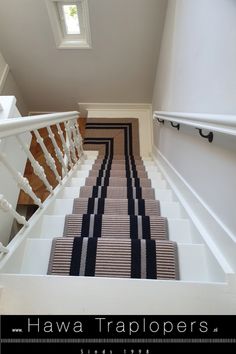 the stairs are lined with black and white carpet