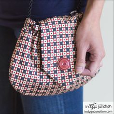 a person holding a purse with a button on it