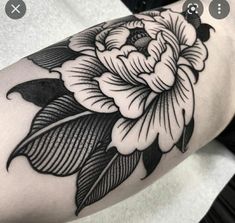 a black and white flower tattoo on the right arm, with leaves around it's edges