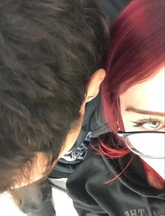 two people with red hair and glasses looking at each other