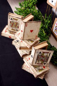 four playing cards are stacked on top of each other in front of some greenery