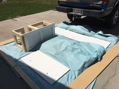 the back end of a pickup truck is being constructed with plywood and plastic sheeting