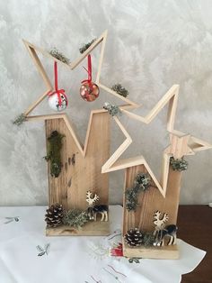 two wooden stars with ornaments hanging from them