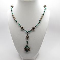 "Inventory #: NVCJ-160 Pretty 26\" Green & Clear Glass Bead Necklace Accented with Filigree Beads & Hammered Tube Beads w/ 3\" Drop This pretty necklace is probably Czech design. It will be a beautiful accessory that will get lots of compliments! Metal: Ten 10mm round brass filigree beads and four 26mm x 5mm hammer stamped brass tubular beads all on brass wire Size: 26\" long with 3\" drop. The mannequin's neck is 14 1/2\" for reference. Stones: Cone shaped green glass beads 5.3mm wide x Green Czech Glass Necklace With Dangling Beads, Green Beaded Czech Glass Jewelry, Green Czech Glass Beaded Chain Jewelry, Green Czech Glass Jewelry With Beaded Chain, Vintage Green Beaded Chain Jewelry, Vintage Green Jewelry With Beaded Chain, Green Czech Glass Beaded Necklace With Dangling Beads, Antique Green Beaded Necklace As Gift, Antique Green Beaded Necklace For Gift