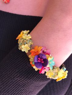 Pretty Petunia bracelet made with a stunning color mix of deep purple, yellow, orange and a pretty greeny turquoise. Made with an assortment of glass bead and handpainted resin flowers, it is meticulously sewn together by hand. This is just a really lovely piece and matches beautifully with our other pieces shown in Petunia. This is a quality piece of jewelry that will last a life time. Created by designer Colleen Toland who has been creating her unique style of vintage jewelry for more than 30 Whimsical Multicolor Flower Jewelry, Unique Multicolor Flower Bracelet, Purple Nature-inspired Flower Jewelry, Elegant Multicolor Flower-shaped Jewelry, Teal Bracelet, Multicolor Multi-stone Flower Jewelry, Purple Yellow Orange, Multi Coloured Necklaces, Lock Style