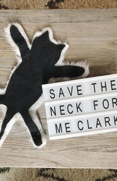 a sign that says save the neck for me clarks on top of a wooden table