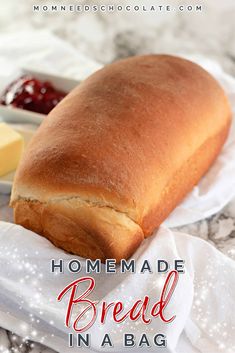 homemade bread in a bag with butter and jelly on the side, sitting on a table