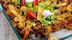 a casserole dish with tortilla shells, cheese and vegetables on top