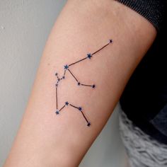 a woman's arm with a small star tattoo on her left forearm and the zodiac sign